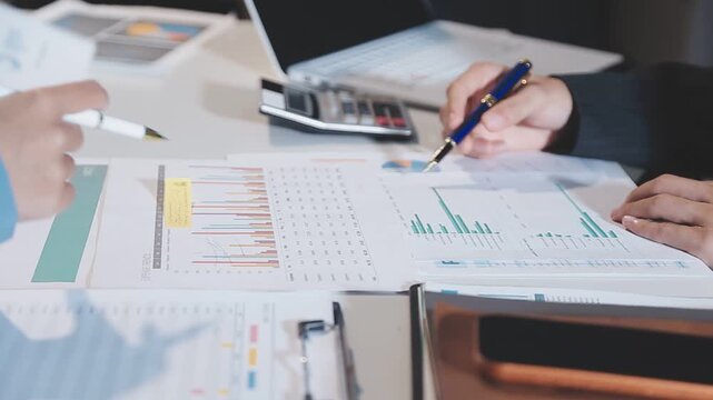 Close up of businesswomen or accountant using calculator calculate while working analytic business report on the workplace, Planning financial and accounting concept.