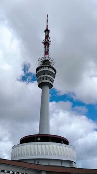 television tower on top of praded mountain with moving clouds