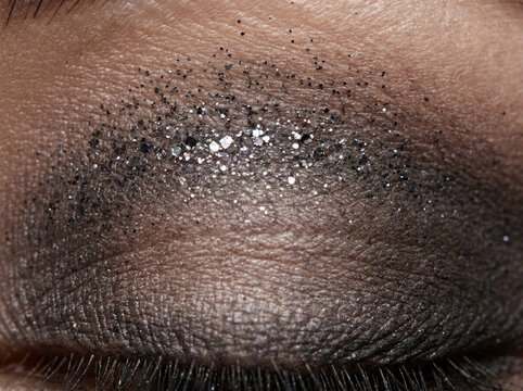 Sparkling smoky eye shadow texture with shimmering particles and deep tones