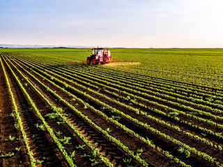 Farmer spraying soybean field with tractor aerial view © oticki