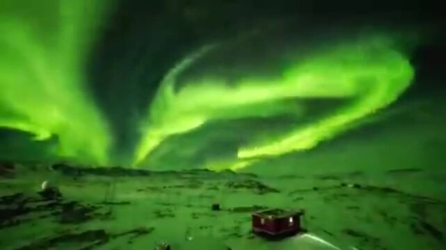 The Aurora Borealis (Northern Lights) dancing beautifully above a silent, snow-covered landscape.