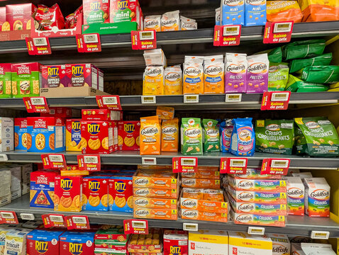 Quebec, Canada, 16 May 2026 : Various snack crackers and biscuits from brands like Ritz and Goldfish are displayed on supermarket shelves with price drop tags.