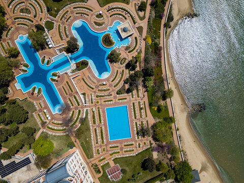 Top down aerial view of luxury beachfront resort hotel with pools