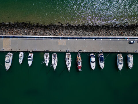 Aerial top down view of small fishing boats moored at the pier in harbor