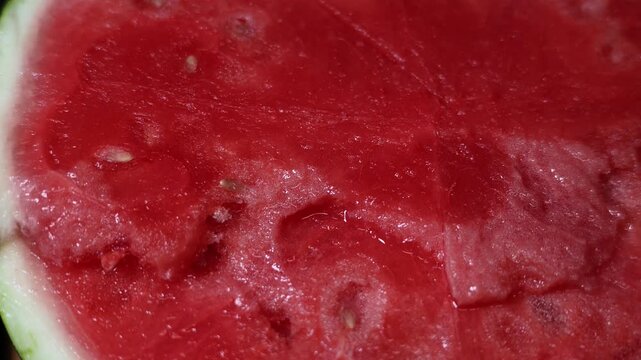 Close-up video capturing the vibrant interior of a watermelon being sliced open
