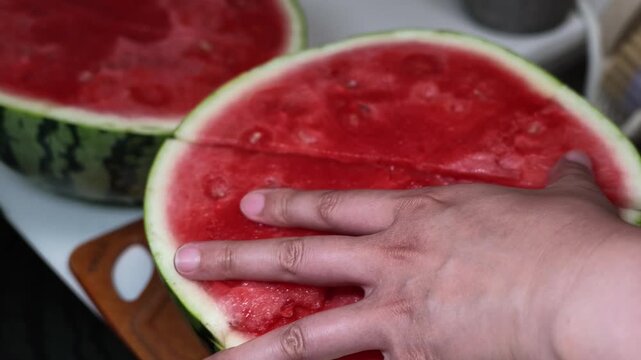 A close-up of a freshly cut watermelon half with vibrant red flesh and green rind