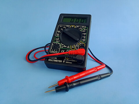 Electronic digital multimeter with probes on blue background