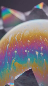 Iridescent soap film stretches across geometric forms with shifting cyan, magenta, gold and violet colors, realistic optical effects and minimalist luxury aesthetic with generous copy space.