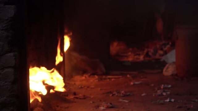 Fire is coming out of kiln from pottery oven, Dharavi area, Mumbai, India
