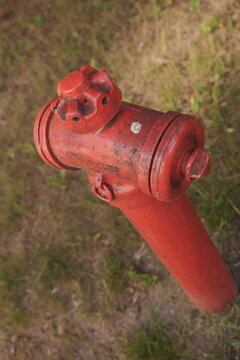 Vertical Bright Red Fire Hydrant in Parched Dry Grass High Angle View Emergency Preparedness Safety Concept Outdoor Utility Equipment