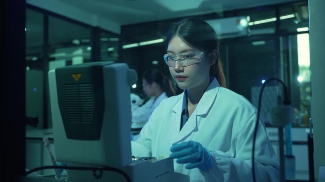 Asian scientist conducting a DNA experiment using a thermal cycler for PCR analysis in a research laboratory