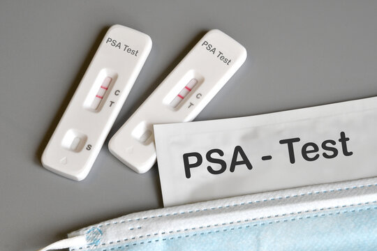 A positive result on a rapid Prostate-Specific Antigen (PSA) test device alongside a medical mask. PSA is a tumor marker used to detect prostate cancer.