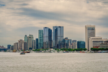 Obraz premium Modern Waterfront Skyline and Corporate High-Rises Along the Huangpu River Under an Overcast Sky in Shanghai, China
