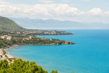 Naklejka premium Panoramic aerial view of a coastal resort town nestled against green hills and the sea