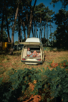 Man Relaxing in Open Vintage Campervan in Pine Forest &ndash; Van Life Lifestyle