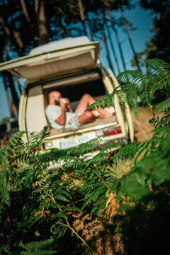 Man Relaxing in Open Vintage Campervan in Pine Forest &ndash; Van Life Lifestyle