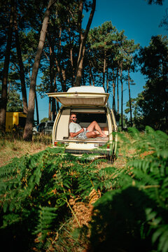 Man Relaxing in Open Vintage Campervan in Pine Forest &ndash; Van Life Lifestyle