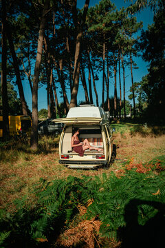 Man Relaxing in Open Vintage Campervan in Pine Forest &ndash; Van Life Lifestyle