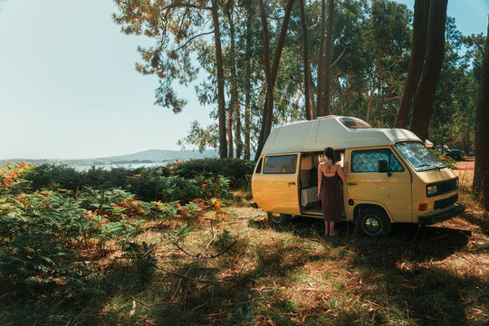 Couple Relaxing in Open Vintage Campervan in Pine Forest &ndash; Van Life Lifestyle