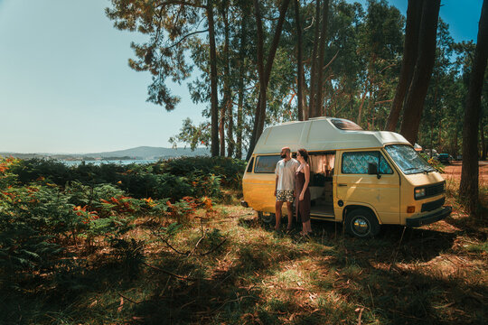 Couple Relaxing in Open Vintage Campervan in Pine Forest &ndash; Van Life Lifestyle