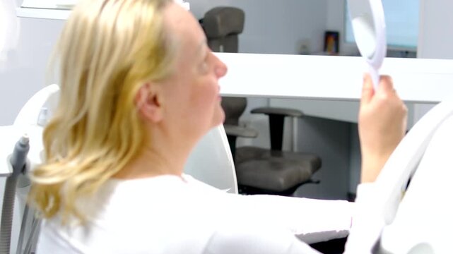 Dental implant crown placement using cheek retractor implant screwdriver and saliva ejector followed by patient smiling at beautiful treatment result in mirror