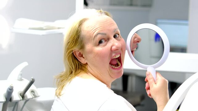 Dental implant crown placement using cheek retractor implant screwdriver and saliva ejector followed by patient smiling at beautiful treatment result in mirror