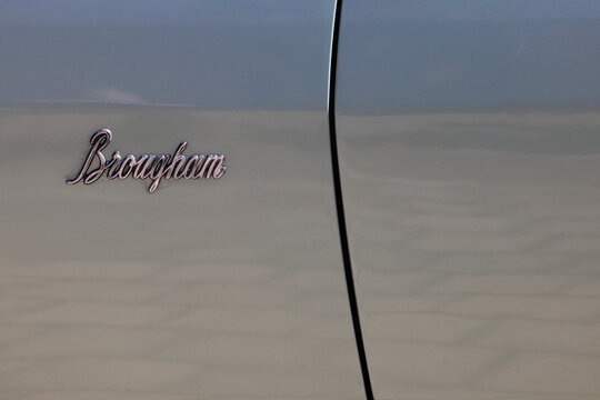 Perth, Western Australia, Australia - May 3 2026: Classic vintage luxury car body panel, chrome cursive brougham script emblem badge. Metallic grey paint oldtimer vehicle bodywork