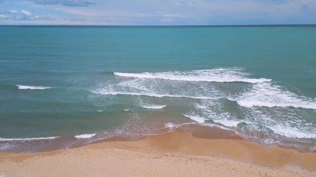 Aerial View of Waves Crashing on Sandy Beach and Open Sea