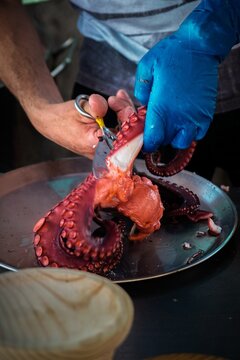 Man Cutting Fresh Octopus with Scissors &ndash; Traditional Galician Spanish Street Food Preparation - Pulpo a la Gallega