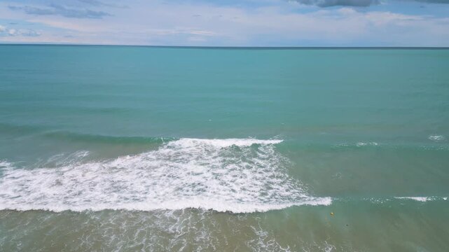 Aerial View of Waves Crashing on Sandy Beach and Open Sea