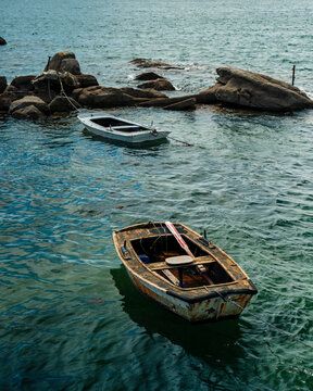 Two Rustic Wooden Fishing Boats Moored on Rocks by Calm Atlantic Sea