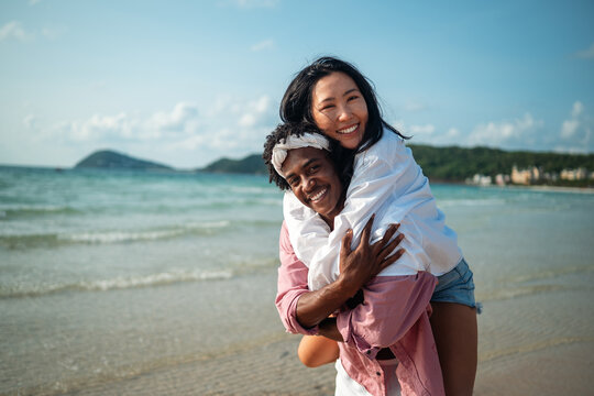 Carefree couple enjoying a tropical beach vacation, laughing making unforgettable memories together