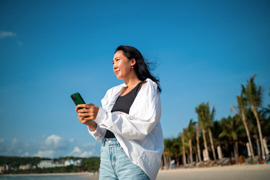 Influencer taking a selfie on a tropical beach, enjoying vacation, social media content creation