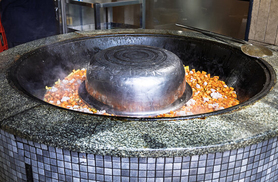 Preparing traditional zirvak with carrots and onions before adding rice for authentic Uzbek plov.