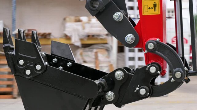 Detail shot of a mini excavator digging bucket and mechanical grapple thumb attachment. Heavy equipment tools for construction and earthmoving. High quality 4k footage