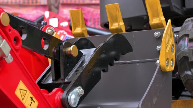 Detail shot of a mini excavator digging bucket and mechanical grapple thumb attachment. Heavy equipment tools for construction and earthmoving. High quality 4k footage