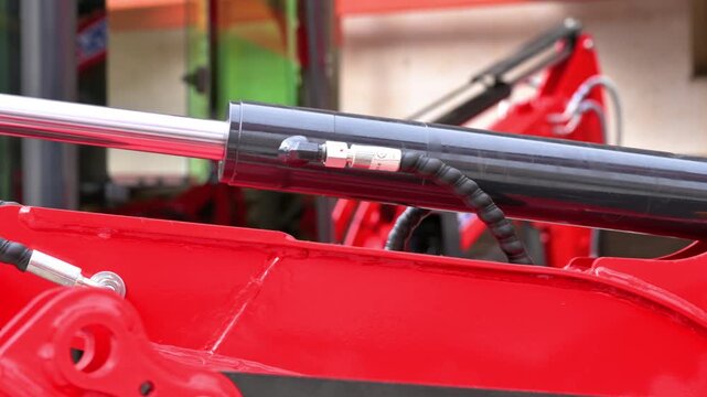 Macro tracking shot of a shiny chrome hydraulic piston rod on heavy industrial machinery. Engineering and fluid power concept. High quality 4k footage