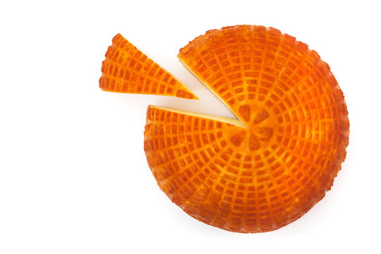Piece of fresh homemade smoked cheese with a slice on a white background. Top view.
