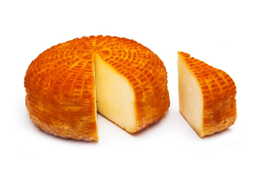 Piece of fresh homemade smoked cheese with a slice on a white background. Side view.