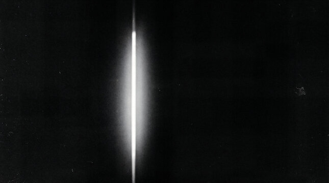 Abstract light beam in dark space, vertical glowing slit flare. Minimal black background with neon white illumination