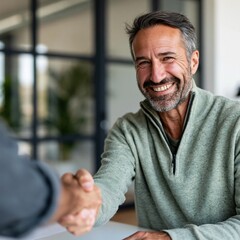 Fototapeta premium Smiling middle aged man shaking hands in modern office background for business agreement banner and corporate website partnership marketing