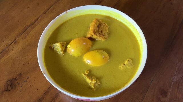 4K Top View Video of Indonesian Gulai Telur Tahu Tempe Coconut Curry Steaming in Bowl for Asian Cuisine and Food Documentary Footage
