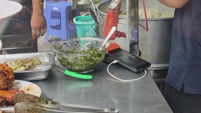 Wide shot of a bustling Vietnamese street food stall, featuring grilled meat, scallion oil, and rice pot