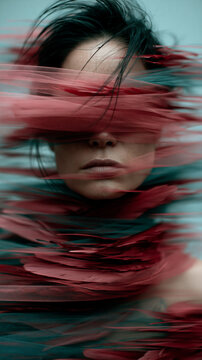 Motion Blur Portrait of Person with Flowing Red Fabric in Low Light
