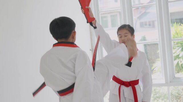 Children practicing martial arts skills in a training session in a dojo