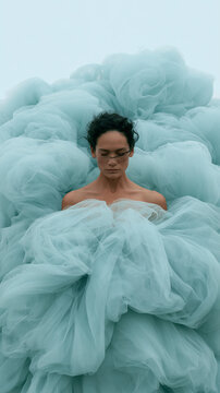 Woman in Flowing Blue Tulle Dress Posing with Dramatic Fabric Swirl High Angle Shot