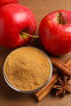Red apples with cinnamon and star anise on wooden background. Top vertical view