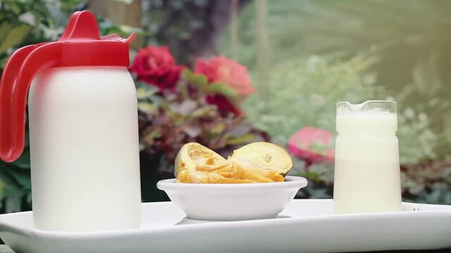 Fresh Milk Pitcher and Glass with Lucuma Fruit Served on a White Tray Outdoors