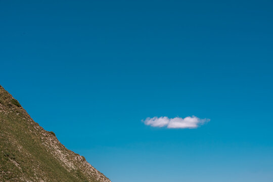 Petit nuage blanc isol&eacute; dans un ciel bleu pur &agrave; c&ocirc;t&eacute; de la pente escarp&eacute;e du Mol&eacute;son