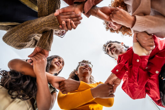Diverse people joining hands forming strong support circle